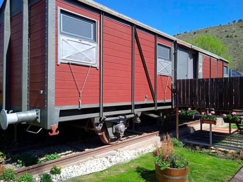 a red train car sitting on the tracks at El Vagón de Baides in Baides