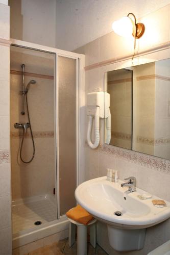 a bathroom with a sink and a shower with a mirror at Les Combes in La Salle