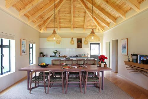 a kitchen with a large wooden table and chairs at Jardin de la Ferme in Franschhoek