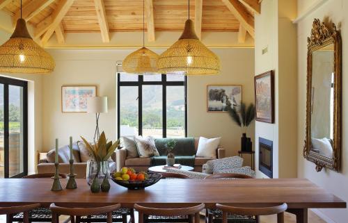 a living room with a table and a couch at Jardin de la Ferme in Franschhoek