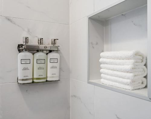 een badkamer met 2 flessen zeep en handdoeken bij Abode Nashville - Germantown in Nashville