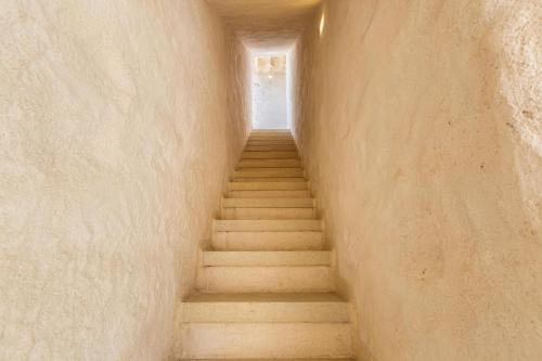 a staircase leading up to a door in a wall at Le Mule Suite and Rooms - Specchia in Specchia