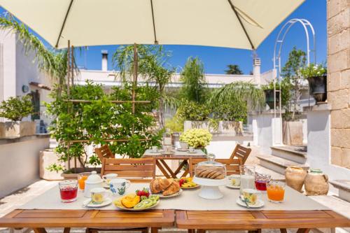 einen Tisch mit Speisen und Getränken auf einer Terrasse in der Unterkunft Le Mule Suite and Rooms - Specchia in Specchia