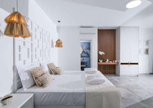 a white bedroom with a large bed with white walls at Sea View Luxury Villa White in Blue in Matala