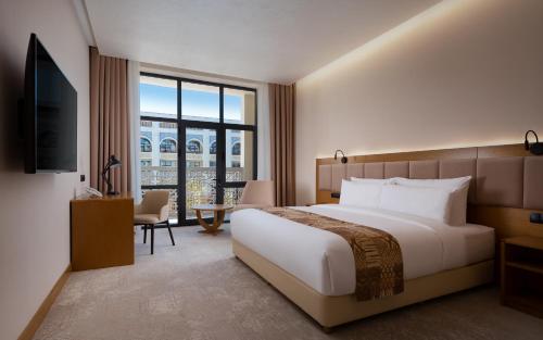 a hotel room with a bed and a television at Farovon Khiva Hotel in Khiva