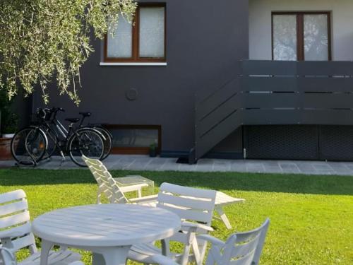 einen Tisch und Stühle im Gras mit einem Tisch und einem Chairsktop in der Unterkunft Olive Tree House in Riva del Garda