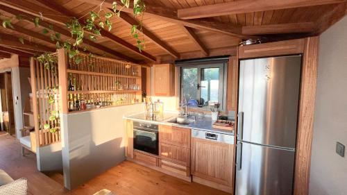 uma cozinha com um frigorífico de aço inoxidável e armários de madeira em Life Butiq Otel em Yalıkavak