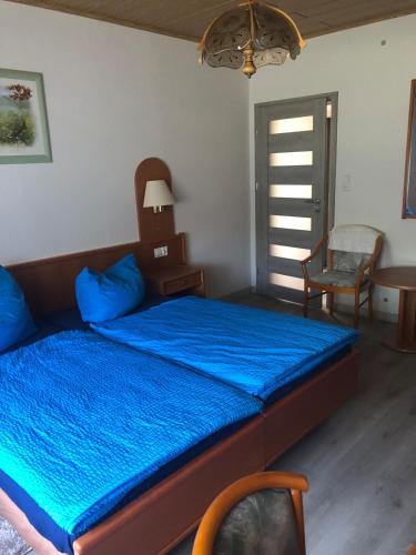 a bedroom with a bed with a blue comforter at Ferienwohnung auf dem Land Wiesenblick Sonnenberg Grambow in Grambow