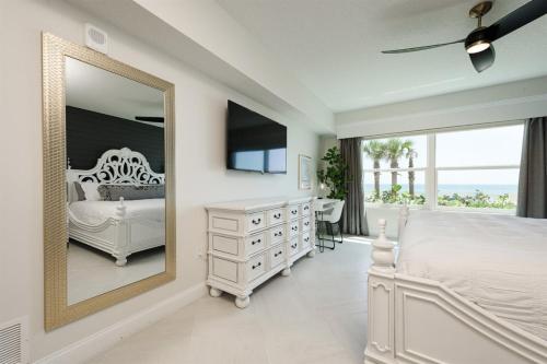 a bedroom with a white dresser and a mirror at Unit 103 Aruba - 3 Bedroom Ocean Front in Daytona Beach