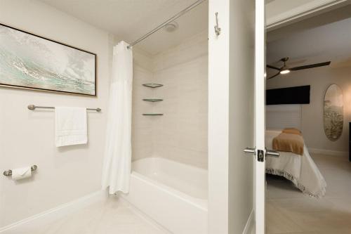 a white bathroom with a tub and a shower at Unit 103 Aruba - 3 Bedroom Ocean Front in Daytona Beach