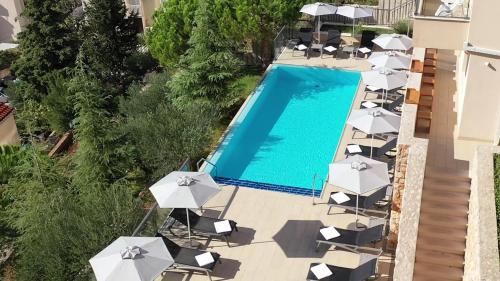 a patio area with chairs, tables and umbrellas at Hotel Adria in Dubrovnik