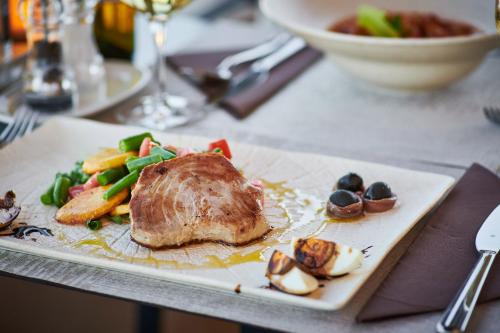 a plate of food with meat and vegetables on a table at Hotel Adria in Dubrovnik