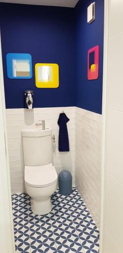 La salle de bains est pourvue de toilettes blanches dans un mur bleu. dans l'établissement Bas Villa, Vue mer, Centre ville, Paradis, calme, à Hyères