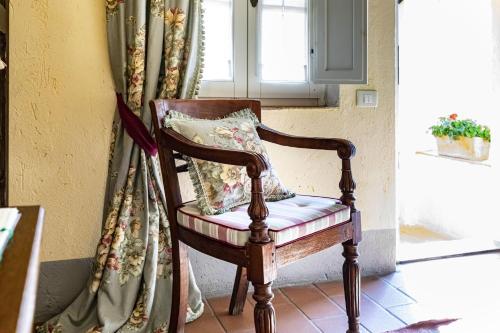 a chair with a pillow in a room with a window at La Ghirlanda Wine Resort in Saragano