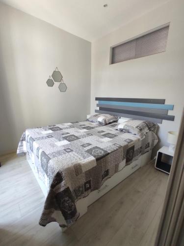 Un dormitorio con una cama con una colcha encima en Agréable T2 au centre de Luchon, en Luchon