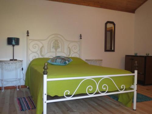 a bedroom with a green and white bed in a room at Casa Capela - Casas do Sinhel in Alvares