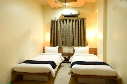 2 camas en una habitación con ventana en Hotel Matrix Inn, en Chākan