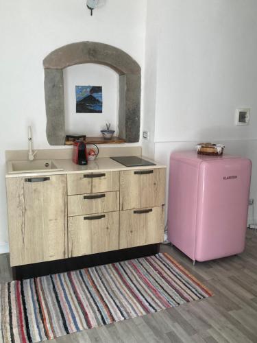 a kitchen with a pink refrigerator and a rug at casa Tuccari Castiglione di Sicilia in Castiglione di Sicilia