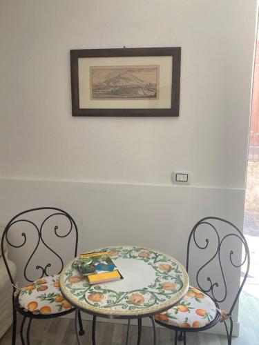 two chairs and a table with a plate on it at casa Tuccari Castiglione di Sicilia in Castiglione di Sicilia