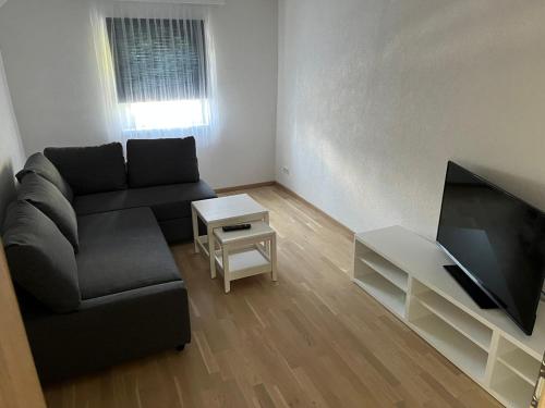 Il comprend un salon doté d'un canapé et d'une télévision à écran plat. dans l'établissement Apartment 2, à Lendorf