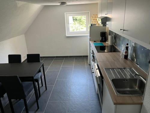 a kitchen with a sink and a table with chairs at Apartment 2 in Lendorf