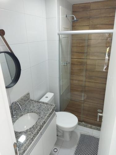 a bathroom with a toilet and a sink and a shower at Flat ótima estrutura in Porto De Galinhas
