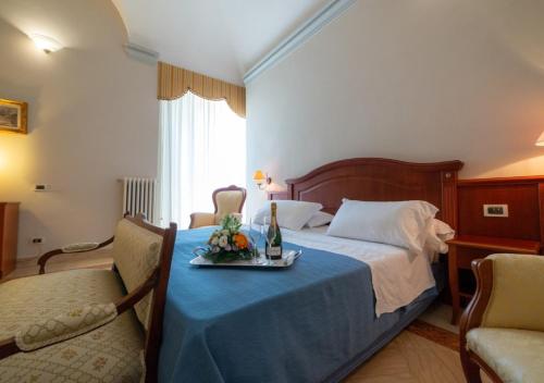 a hotel room with a bed with a tray of fruit on it at Villa Tuscolana in Frascati