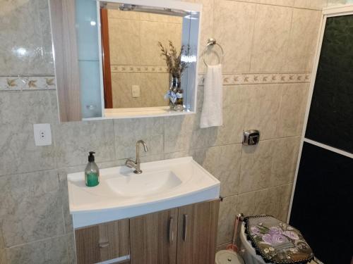 a bathroom with a sink and a mirror at Recanto Santa Teresa in Guarapuava