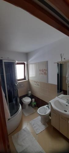 a bathroom with two sinks and a shower and a toilet at Pensiunea Mia in Statiunea Borsa