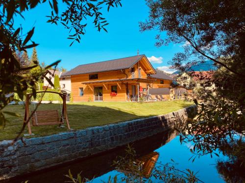 a house sitting on top of a body of water at Chalets Lunz am See in Lunz am See