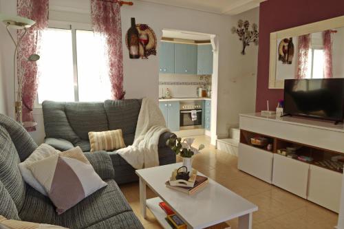 un soggiorno con divano e TV di Casa JIRAFA con la vista a Gran Alacant