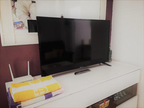 una TV a schermo piatto seduta sulla mensola bianca di Casa JIRAFA con la vista a Gran Alacant