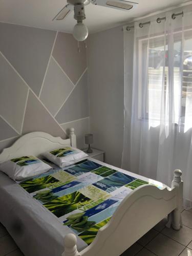 a bedroom with a bed with a quilt on it at appartement des aigrettes saint gilles les bains in Saint-Gilles les Bains