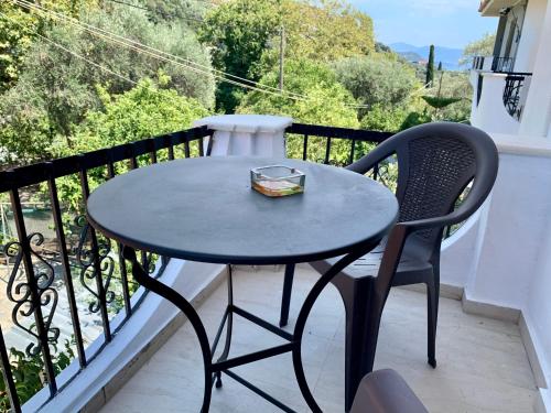 a black table and a chair on a balcony at Tasos house in Anthoúsa