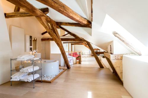 - une salle de bains mansardée avec poutres apparentes et murs blancs dans l'établissement Suite Mana OHANA - Luxe et Authenticité à 2 pas de la Place Ducale avec Parking privé, à Charleville-Mézières