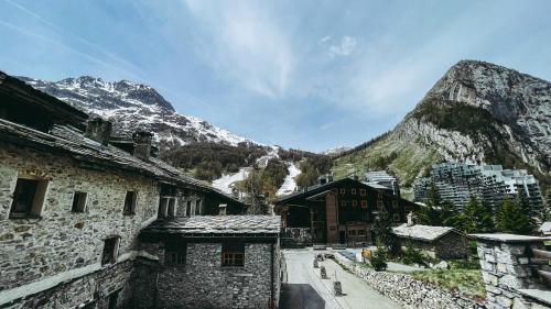 a view of a snowy mountain with buildings and mountains at Appartement esprit chalet - splendide vue montagne à 180 in Val dʼIsère