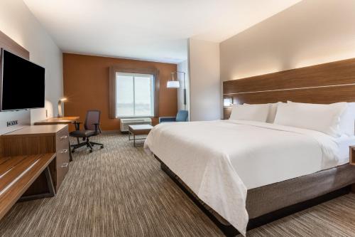 um quarto de hotel com uma cama grande e uma televisão de ecrã plano em Holiday Inn Express & Suites Kearney, an IHG Hotel em Kearney