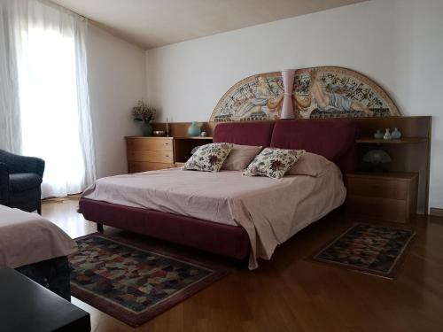 1 dormitorio con 1 cama grande y cabecero grande en ABC Rooms en Valdobbiadene