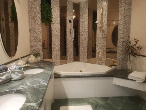 baño con 2 lavabos y bañera con espejos en ABC Rooms en Valdobbiadene