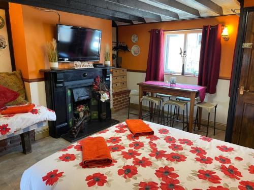 ein Schlafzimmer mit einem Bett und einem Tisch und einem Fernseher in der Unterkunft Yarm cottages Haystack in Kirk Leavington