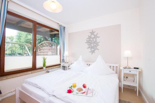 a bedroom with a white bed with fruit on it at Ferienhof Kluvetasch Appartement Nr 3 - Seestern in Rettin
