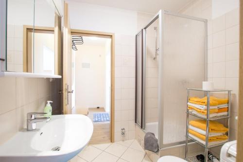 a white bathroom with a sink and a shower at Ferienhof Kluvetasch Appartement Nr 4 Ostseeblick in Rettin