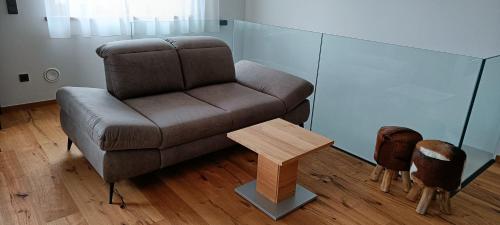 a living room with a brown couch and a wooden table at Hohe Tauern Lofts Panoramabahn by Alpina-Holiday in Dorf