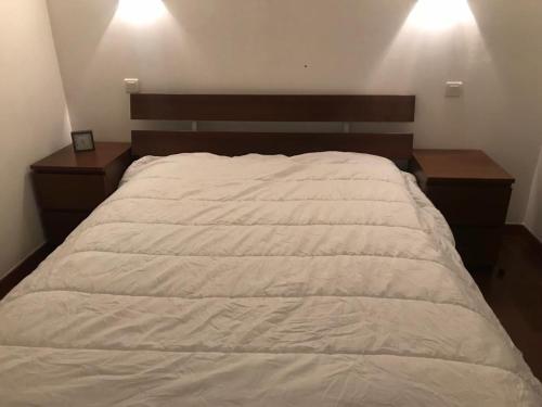 Croix-ChapeauにあるLa campagne dans l'Ocean à LA ROCHELLE les pieds dans la grangeの白い大型ベッド1台(ナイトスタンド2つ付)