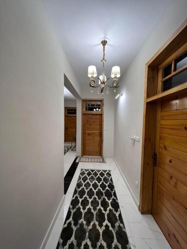 a hallway with wooden doors and a black and white rug at ISLE OF HIGHLAND TOURS Guest House in Gilgit