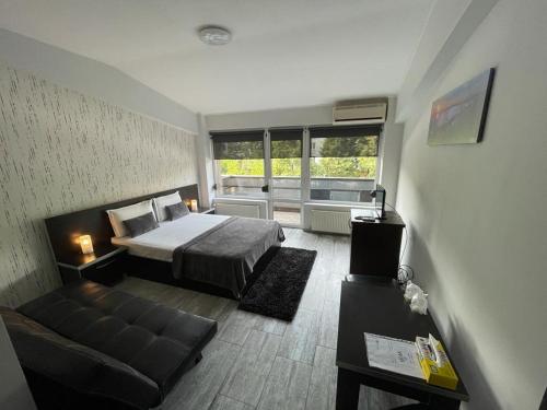 een slaapkamer met een bed en een bank in een kamer bij Hotel Rivoli in Boekarest
