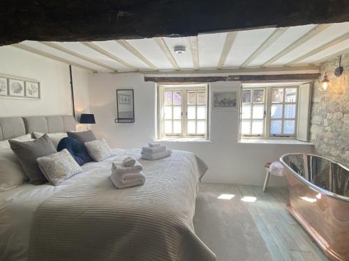 a bedroom with a large bed and a bath tub at Granary Cottage in Weymouth