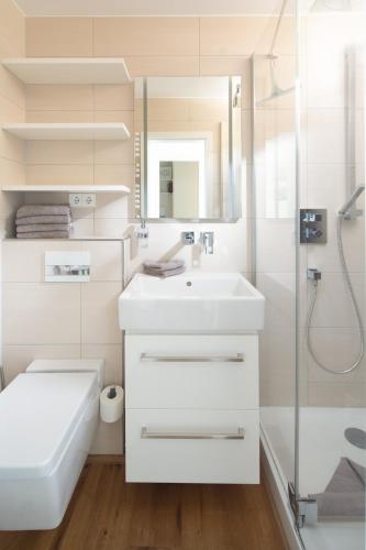 a white bathroom with a sink and a shower at SeaScape in Norderney