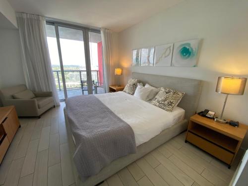 1 dormitorio con 1 cama grande y balcón en BeachWalk 1B 1B Apmt Amazing View 26A, en Hallandale Beach