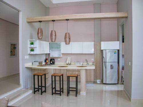 Una cocina con gabinetes blancos y taburetes de bar. en La Bonita Luxury Ecohotel, en Sahagún